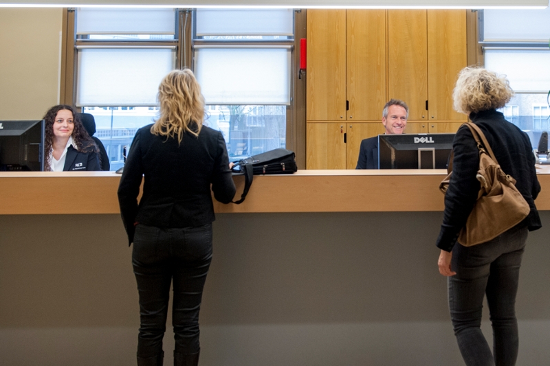 Mensen worden ontvangen bij de balie.